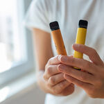 junge Hände halten zwei Vapes