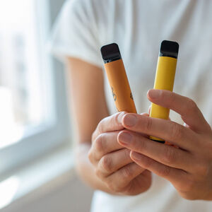 junge Hände halten zwei Vapes