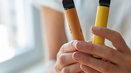 junge Hände halten zwei Vapes